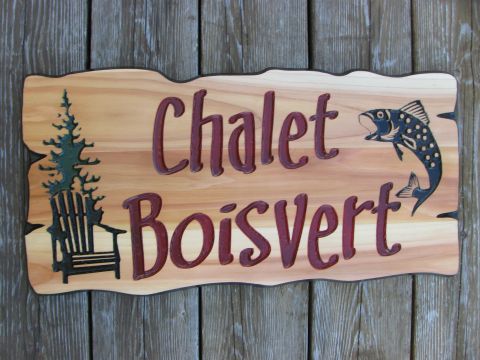 Wood carved sign with chair and trees